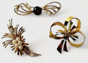 Three various 9ct gold brooches comprising a tied bow, stylised spray with seed pearls and a seed