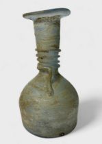 A Roman clear glass bottle, or unguentarium, flared rim and tapering funnel neck to bulbous body,