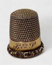 An antique gold thimble, typical form with dimpled crown and skirt, plain frieze with with foliate