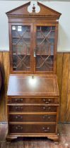 A walnut bureau bookcase, the shaped cornice with dentil moulding, above a pair of astragal glazed