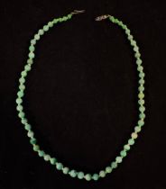 A Chinese graduated Jade bead necklace, individually knotted variegated green beads measuring 6mm to