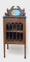 An Edwardian mahogany music cabinet, shaped and inlaid gallery centred by oval bevelled mirror,