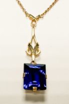 A 9ct yellow gold necklace chain, four-claw set with a rectangular shaped, blue faceted stone,