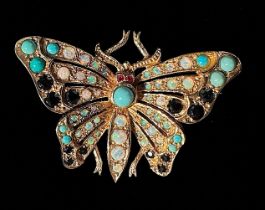 A 9ct gold Butterfly brooch, with ruby eyes, the wings and abdomen set with sapphires, cabochon