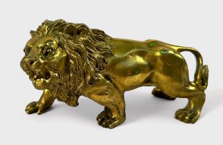 A gilt cast copper alloy figure of a lion, prowling and snarling, 15cm