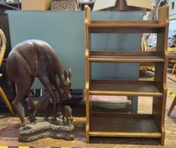 A carved and stained hardwood sculpture of a female deer and her two fawn, one suckling from her