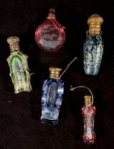 Five various glass perfume bottles including a ruby-flashed and cut, coloured overlaid and cut and a