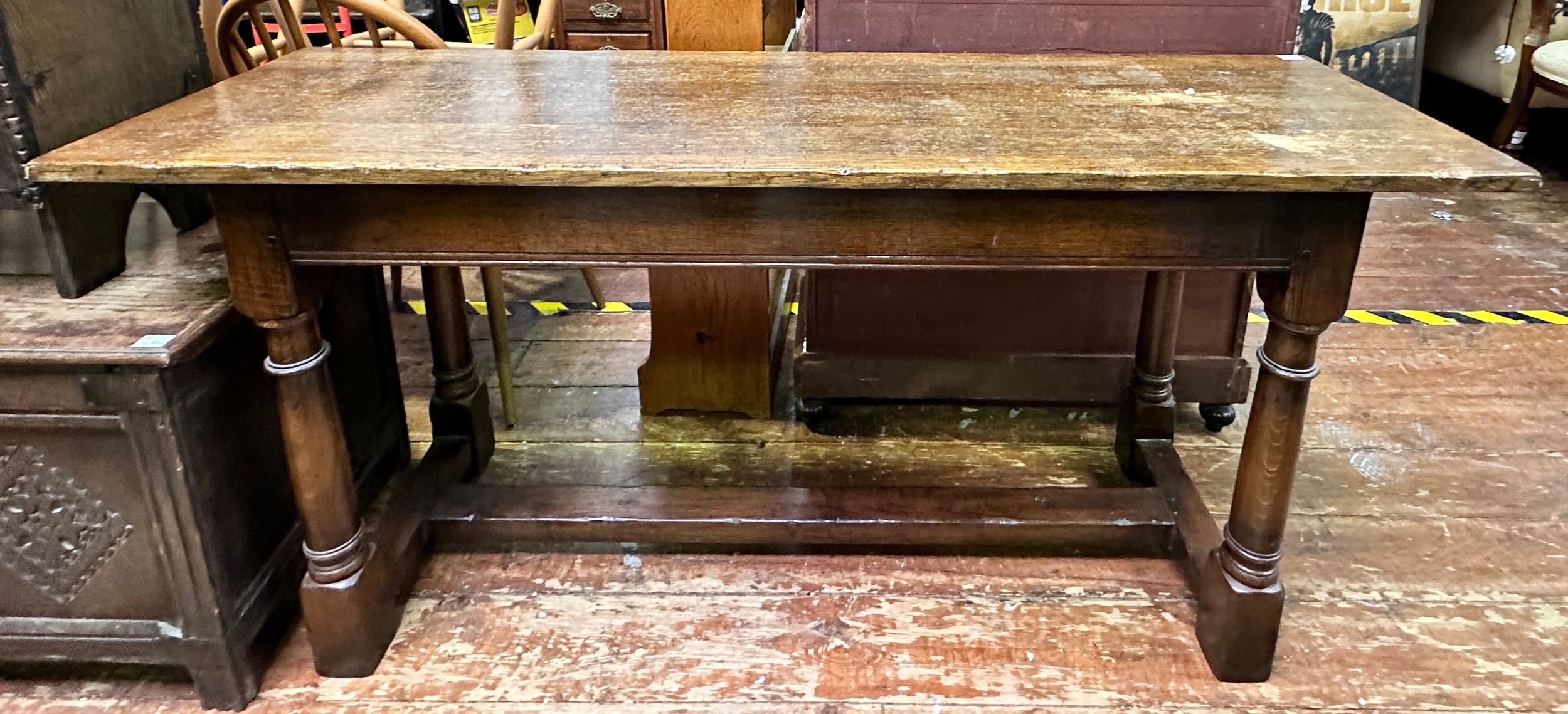 An oak hall/side table, with plank top to plain frieze, raised on turned supports united by