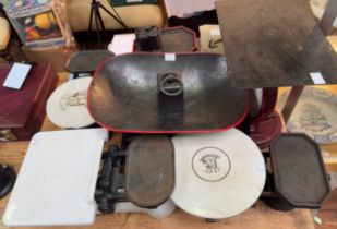 A collection of various cast iron and ceramic weighing scales, with an assortment of iron and