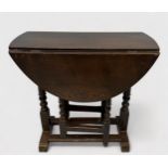 A late 19th/early 20th Century stained oak oval drop-leaf occasional table, gate-leg action base,