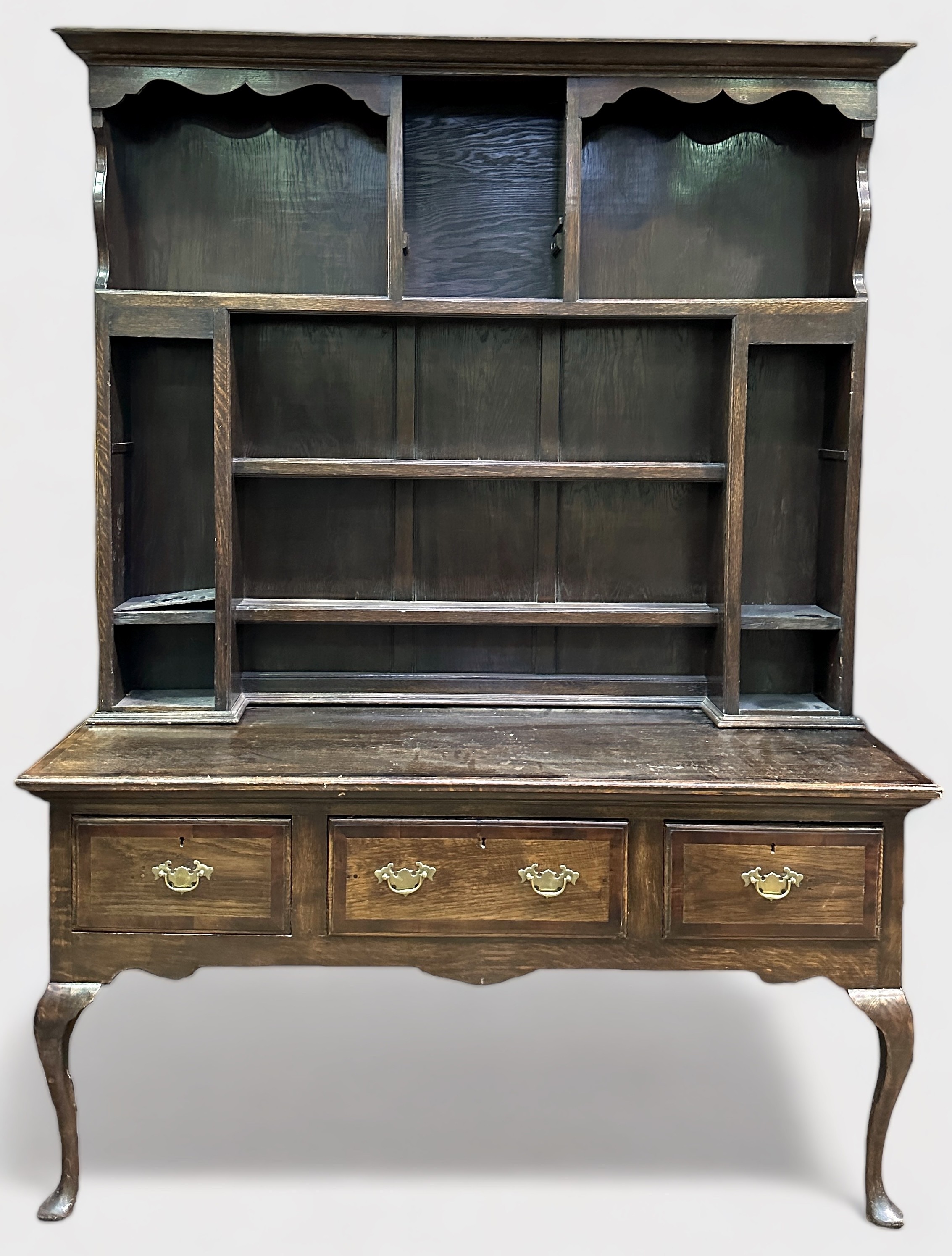 An 18th century and later oak dresser, the later raised back section with shaped cornice, above