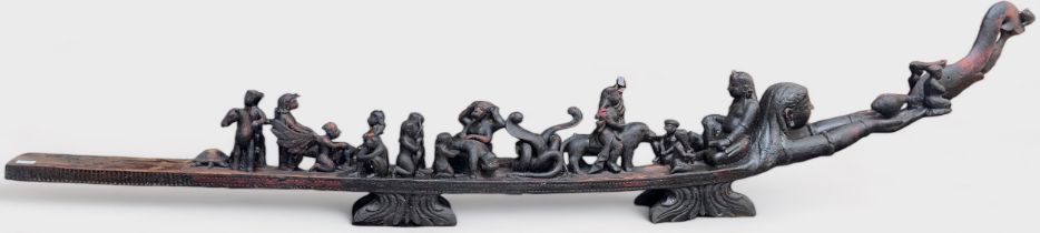 A carved hardwood altarpiece, possibly South American, modelled as a stylised boat with figures
