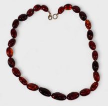 A Cognac Amber Bead Necklace, graduated ovoid beads 25x11mm to 14x8mm, good natural inclusions, 50cm
