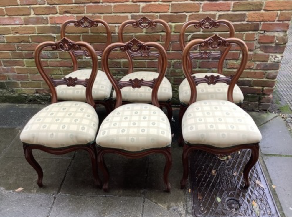 A set of six Victorian style mahogany balloon back standard chairs, with yellow upholstered floral