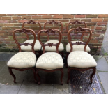 A set of six Victorian style mahogany balloon back standard chairs, with yellow upholstered floral