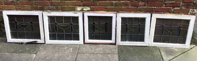 Five pieces of Edwardian stained glass panels all set in a pine window frame, 2 x 50 x 50cm and 3