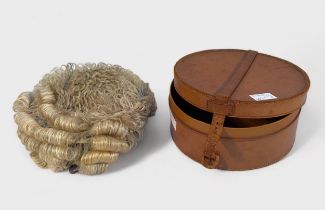 A Barristers horse hair wig, in circular tan leather box with buckle fastening