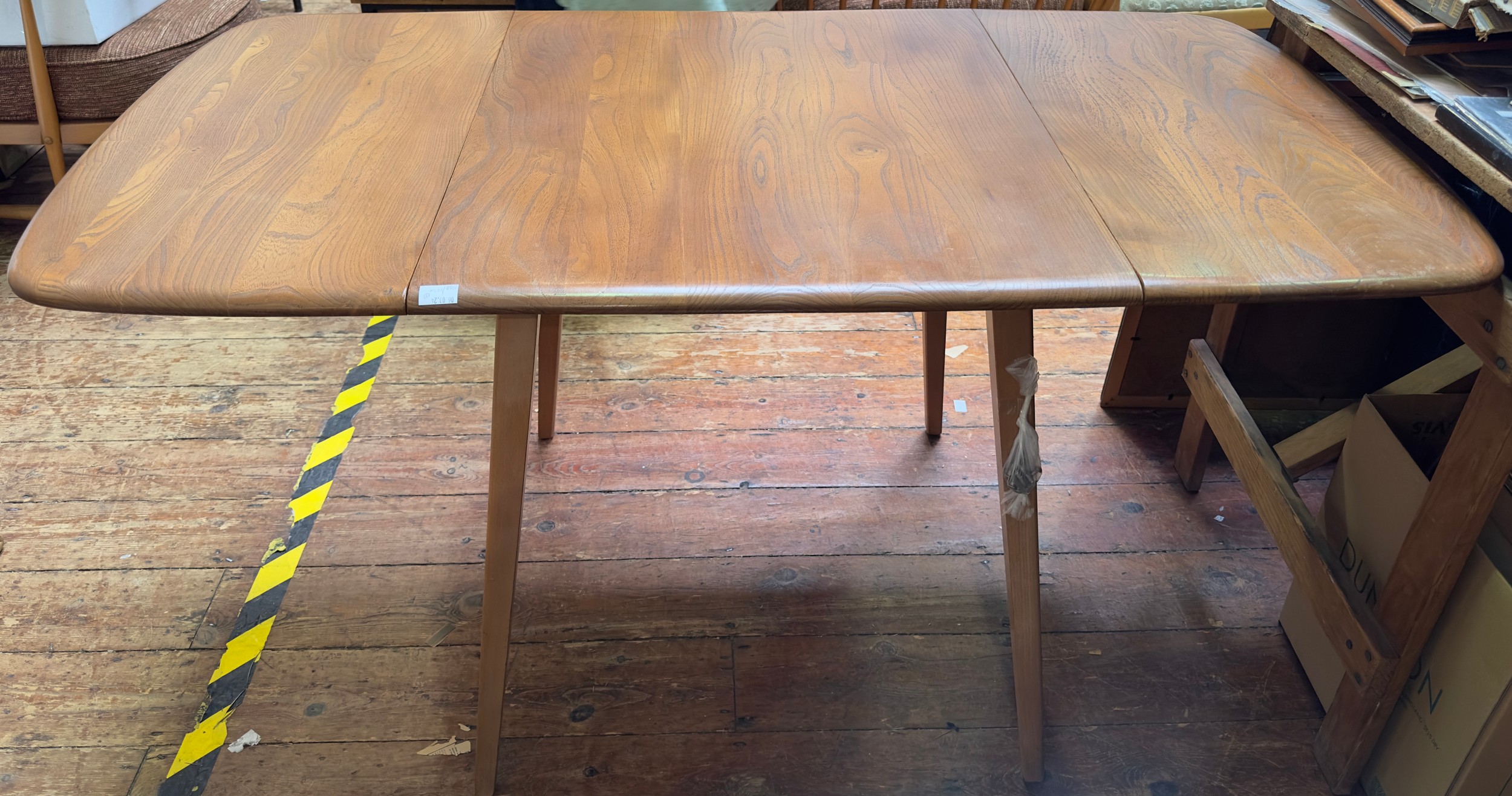 An Ercol blonde elm drop-leaf dining table, model 383, raised on squared, tapering supports, 136cm