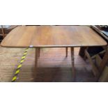 An Ercol blonde elm drop-leaf dining table, model 383, raised on squared, tapering supports, 136cm