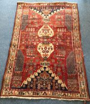 A hand-knotted Caucasian rug, typical stylised floral decoration to red ground, 190cm x 130cm