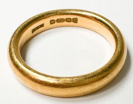 A 22ct yellow gold court-shaped wedding ring, weighs 9.9 grams.