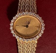 A ladies 18ct gold Omega quartz wristwatch, the oval champagne dial with applied gilt dot hour