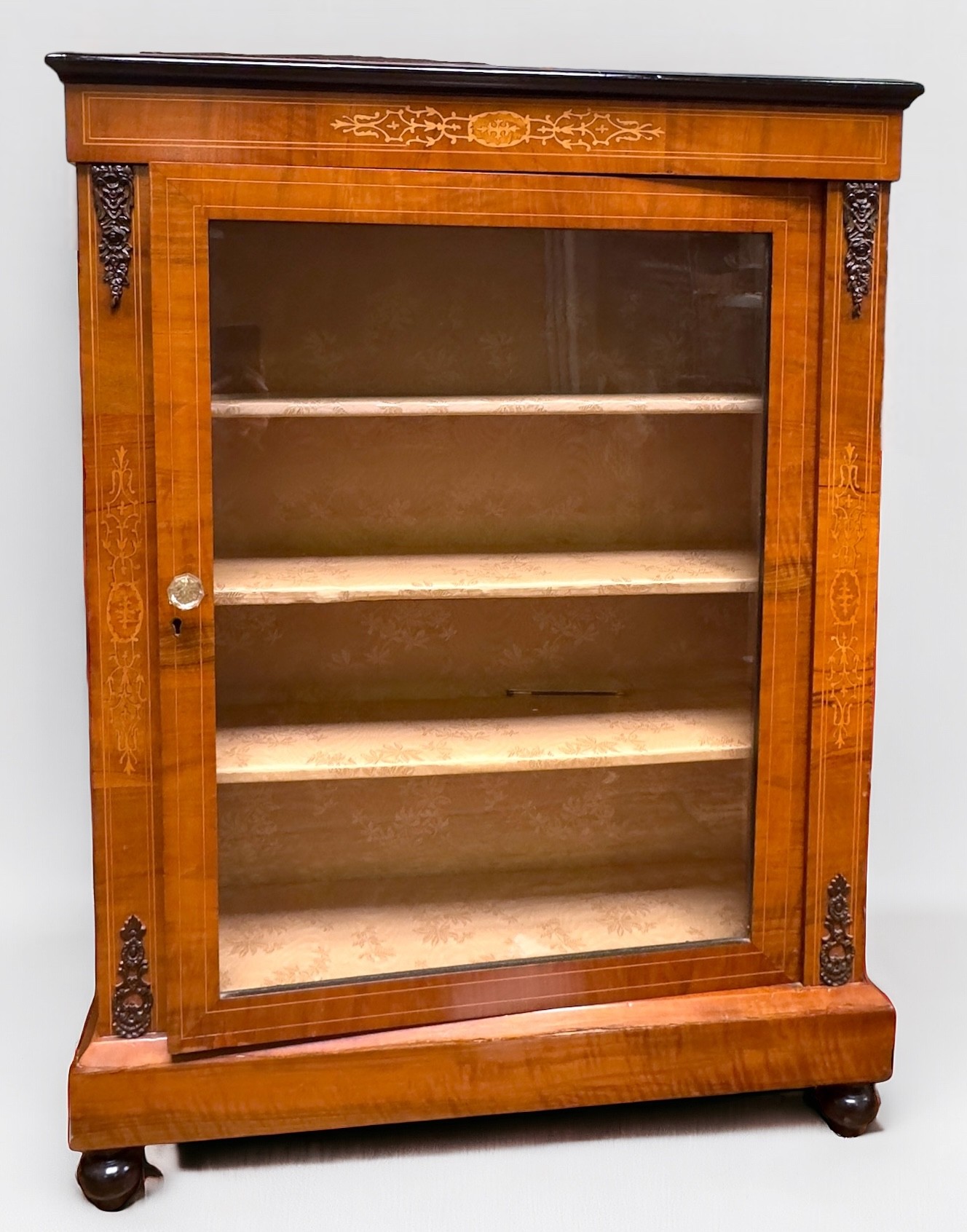 A Victorian inlaid walnut pier cabinet, with single central glazed door enclosing three shelves,