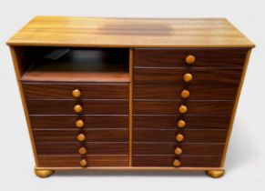 A mahogany and teak sideboard containing 14 drawers with turned pulls and pigeonhole, by John Austin