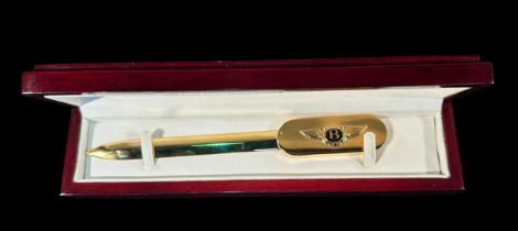 A scarce and unusual gold-plated letter opener with applied, Bentley motors emblem to handle, in