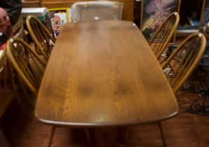 An elm Ercol dining table, with rectangular plank top, raised on trestle supports with stretcher,