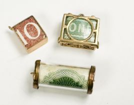 Three various 9ct gold bracelet charms, encapsulated notes, including a Ten Shilling note, a One