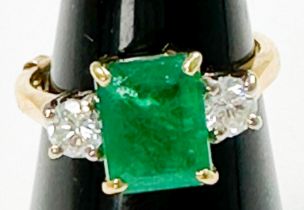 An 18ct gold dress ring, four-claw set with a rectangular-shaped emerald, measuring approximately