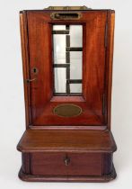 A Late 19th Century walnut Cox's Patent Till, with glass panel and sliding penny-drop, hinged door