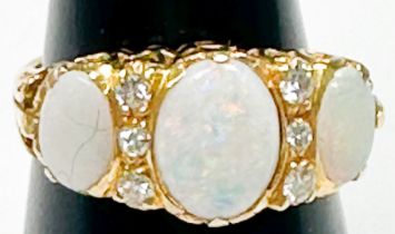 An 18ct yellow gold dress ring, set with three oval-shaped opals, centre opal measuring 10 x 8mm,