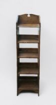 A Liberty & Co 'style' stained oak bookcase, of narrow proportions, with fret-cut three-quarter