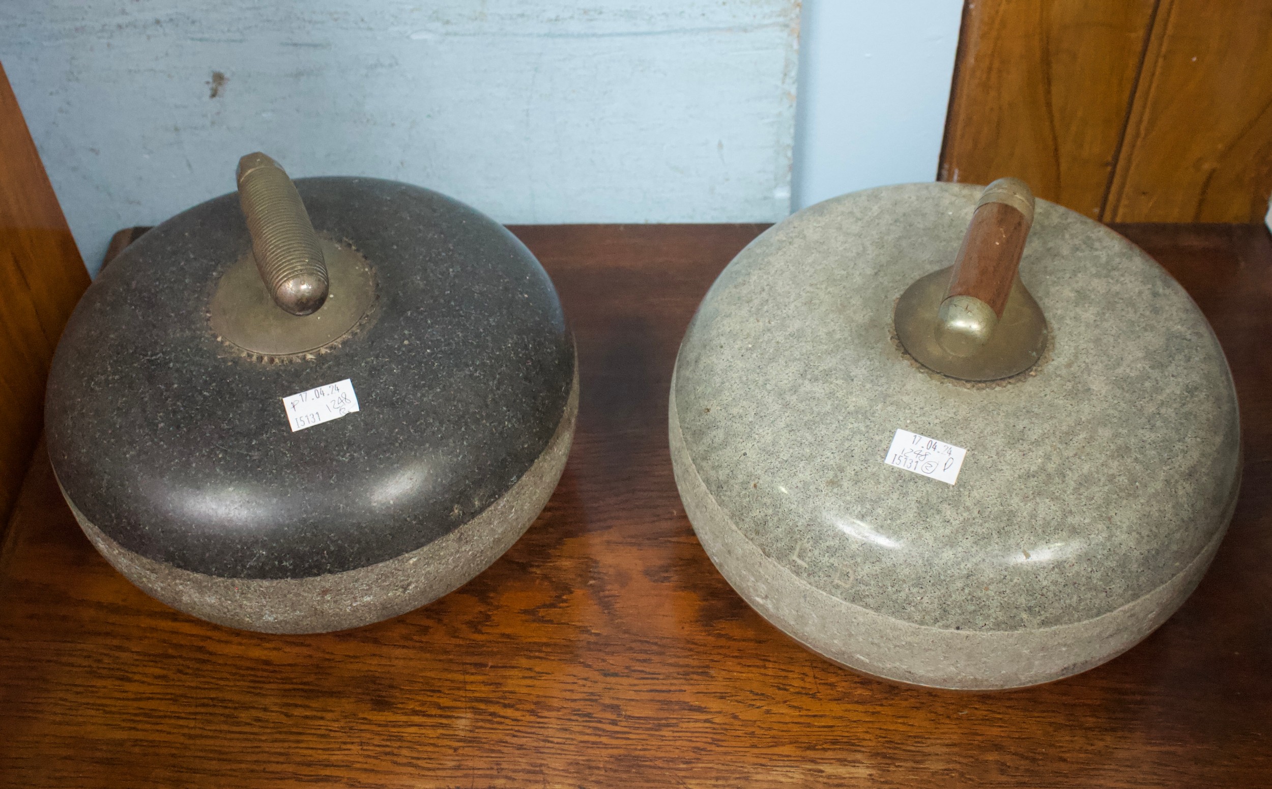 Two various granite curling stones, one with ribbed handle, diamond registration mark and stamped '