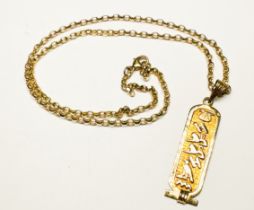A 9ct gold hieroglyphic pendant and 9ct gold belcher chain, total weight 7.2 grams.