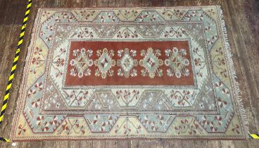 A hand-knotted Caucasian large wool rug, worked in brick-red, yellow, duck egg blue and neutral