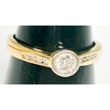 An 18ct yellow gold solitaire diamond ring, bezel-set with a round brilliant cut diamond,