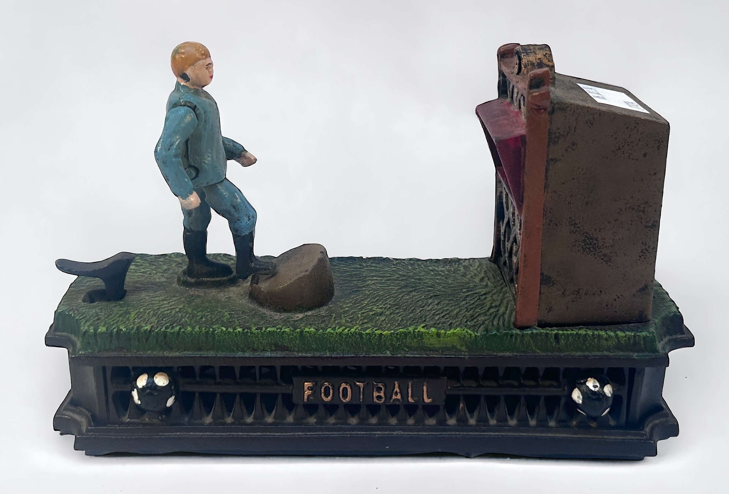 A painted cast iron novelty mechanical money bank or box, Football Bank, modelled as a footballer