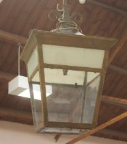 A large painted metal lantern, with decorative scrolled finial and glass panelled sides (one side