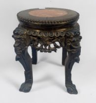 A Chinese carved and ebonised hardwood jardiniere stand, with mask-capped cabriole supports and