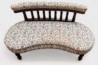 An Edwardian kidney-shaped parlour sofa, with bobbin spindle back and floral cream upholstered