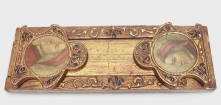 A late 19th Century/early 20th Century gilt painted book slide, shaped incised ends with circular