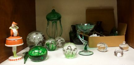 A collection of green glass items including various paperweights, oil lamps, stemmed glasses,