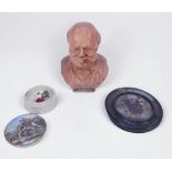 A terracotta bust of Winston Churchill smoking a cigar, with etched initials to back, 21cm tall,
