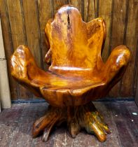 A rustic seat carved from a single tree root.