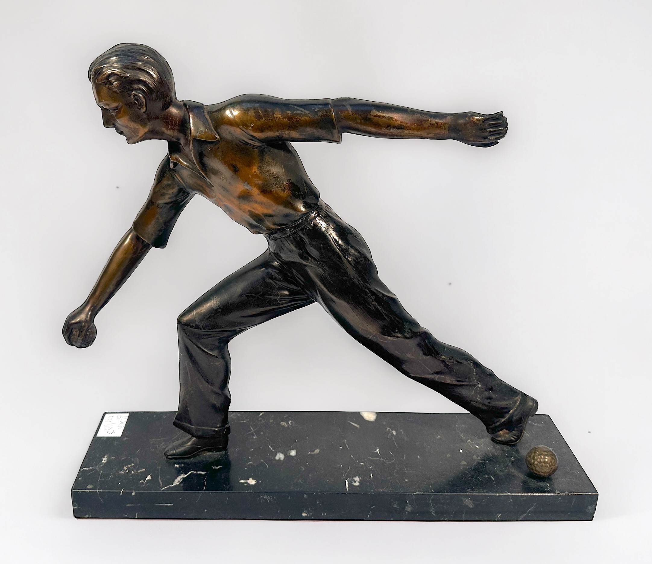 A bronzed metal sculpture of a man playing Pétanque, raised on marble base, 38cm long - Image 2 of 3