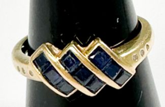 An 18ct yellow gold dress ring, invisible set with three rows of three princess cut sapphires,