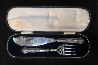 A pair of Victorian silver fish servers with scrolling foliate engraved blades, one side a vacant